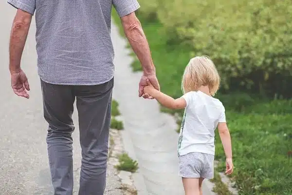 Vater und Tochter halten Händchen und laufen