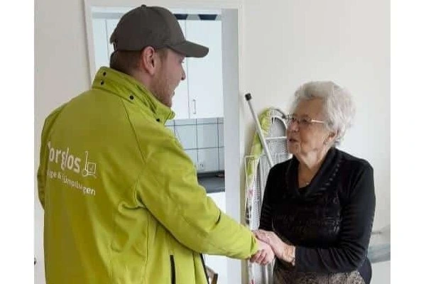 Sorglos-Kundin Frau Vorbeck bedankt sich mit Handschlag bei Umzugshelfer mit Handschlag