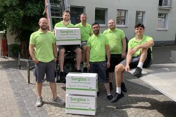 Das Umzugsteam sitzt auf einen Möbellift. Davor stehen Umzugskartons.
