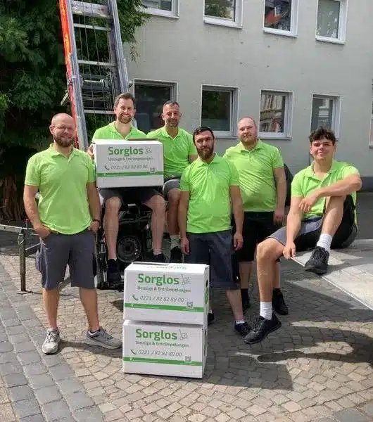 Das Umzugsteam der Firma Sorglos Umzüge & Entrümpelungen posiert vor einem Möbellift.