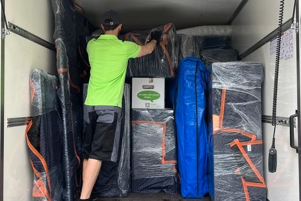 Umzugshelfer sichert Umzugsgut in Umzugstransporter