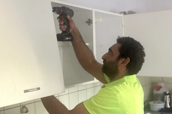 Umzugshelfer demontiert Küchenschränke