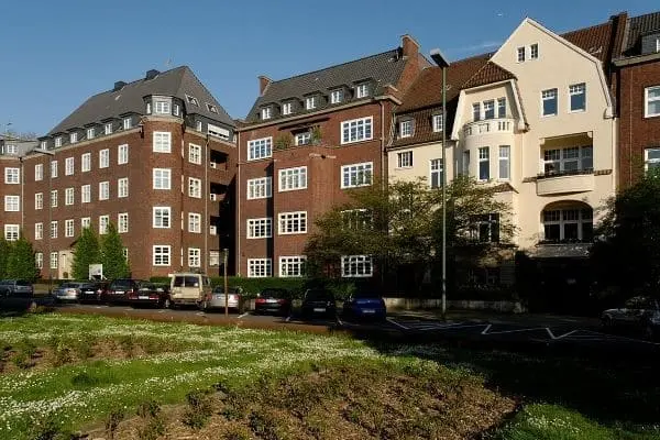 Reihenhauszeile mit Backsteinfassaden und mehreren geparkten Autos davor in Düsseldorf Golzheim