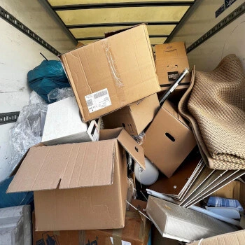Innenraum eines Lkw mit mehreren Kartons, einem Teppich und weiteren Gegenständen zur Entsorgung