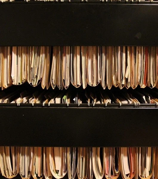 Drei Reihen mit hängenden Aktenordnern in einem Aktenschrank