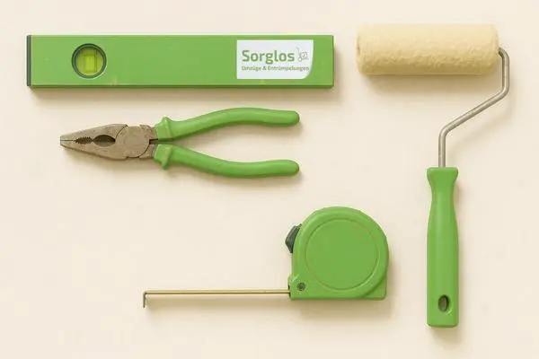 Grüne Wasserwaage mit Schriftzug 'Sorglos', grüne Kombizange, grünes Maßband und Farbroller mit grünem Griff auf hellem Untergrund