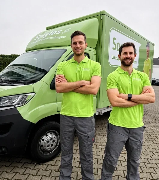 Magnus Wonneberger und Gabriel Krämer, die Gründer von Sorglos Umzüge & Entrümpelungen, stehen vor dem "Sorglos-Mobil"